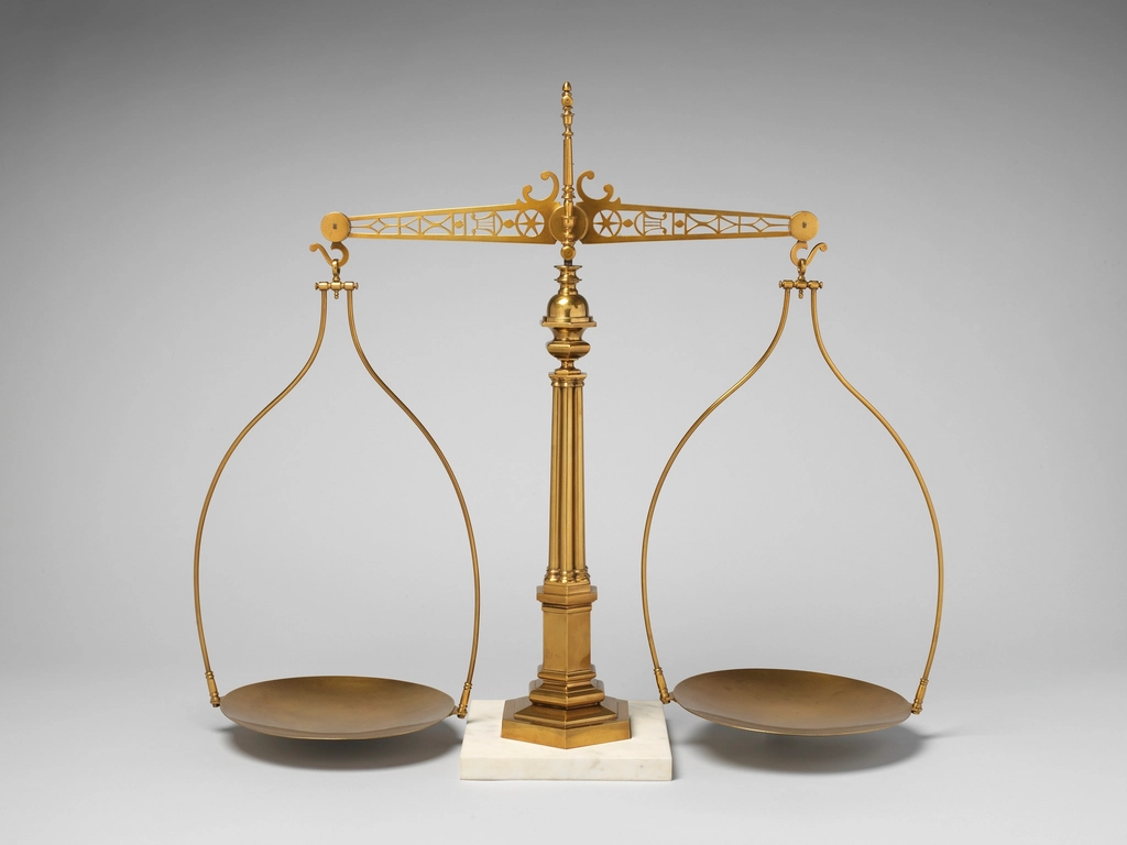 An antique brass balance scale with two empty pans
